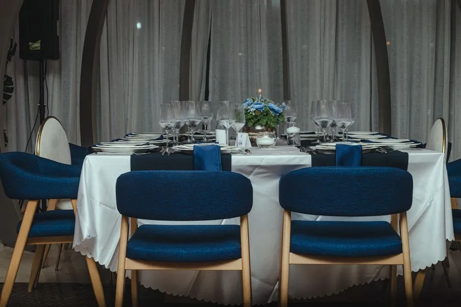 Dirigeants échangeant dans une loge VIP lors d'un match, table dressée et vue sur le terrain